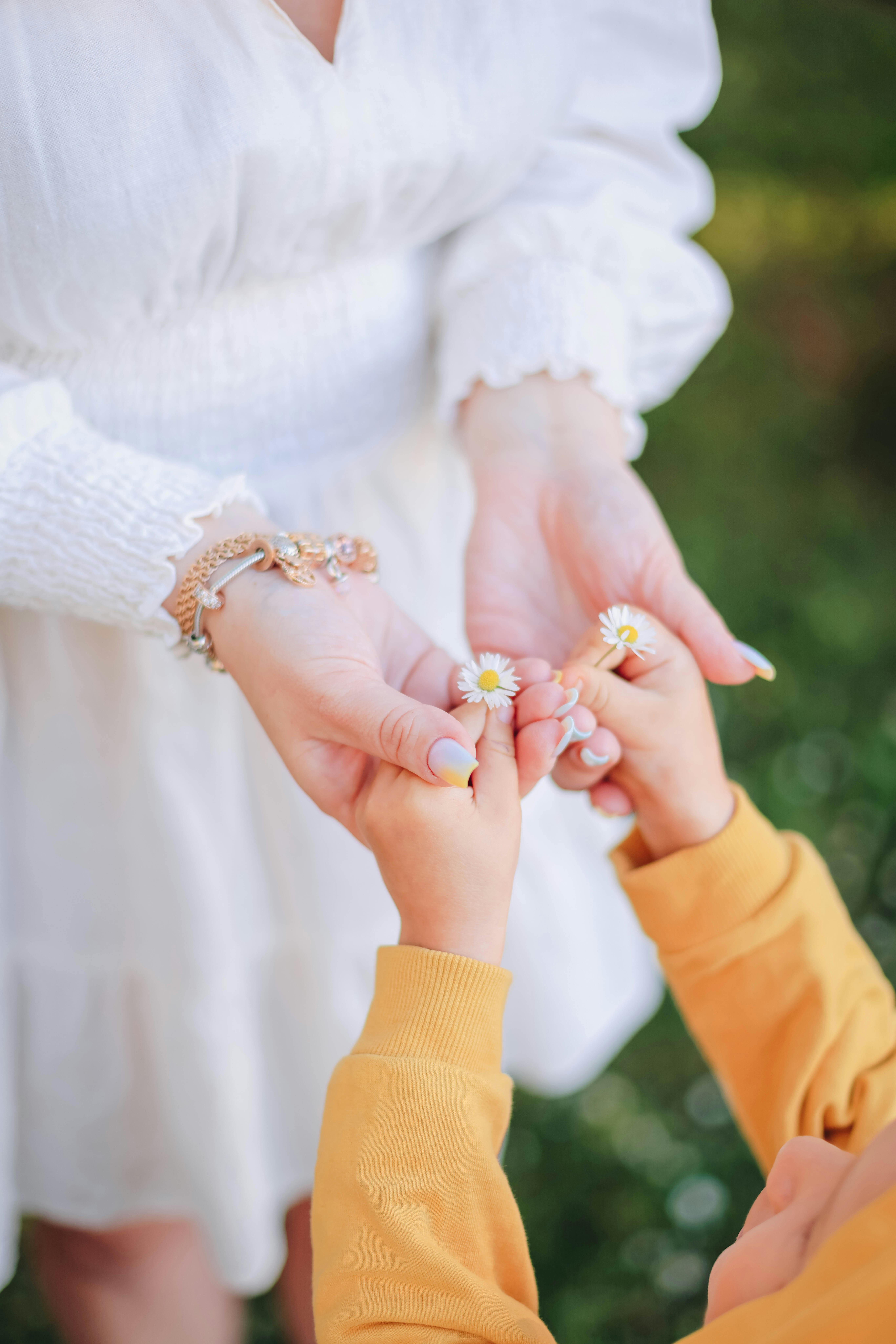 Close-up of parent holding baby's hand, showing bonding